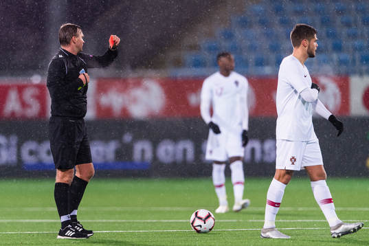 Referee Segei Lapochkin gives a red card to Diogo Queiros