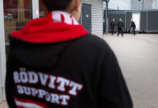En Örebro supporter tittar på Örebrospelarna som värmer