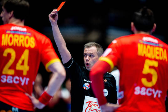 The referee gives a red card to a Spanish player
