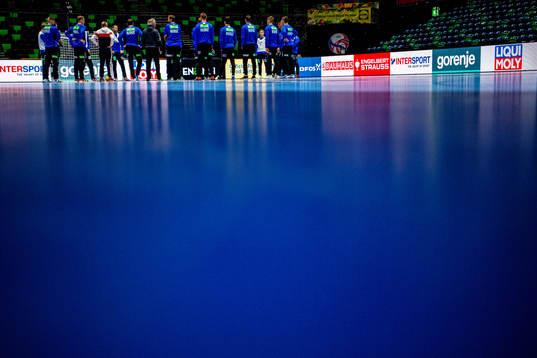 Players and staff of Norway gather in a circle at a