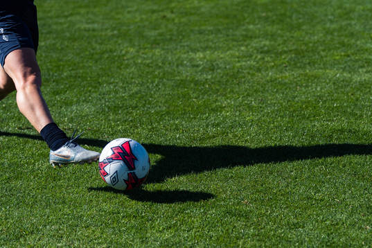 A shadow of a player and a football