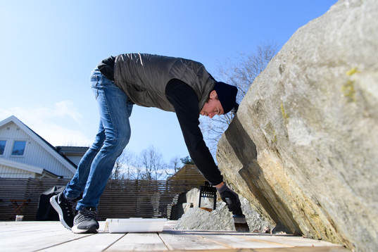 Danny Ervik oljar altanen i sitt hem