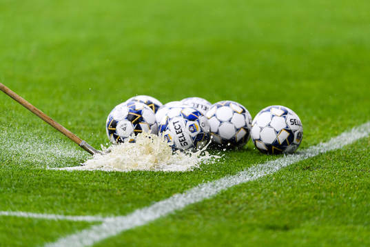 Fotbollar på blött gräs
