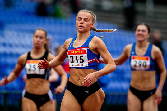 Andrea Rooth competes to win the women's 100 meter hurdles