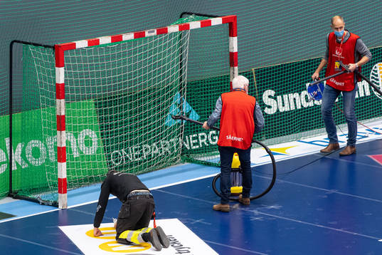 Arenapersonal torkar och dammsuger bort glassplitter från