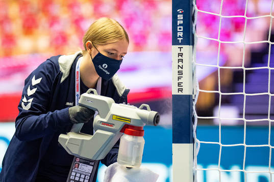 A steward steams the goalpost to disinfect it