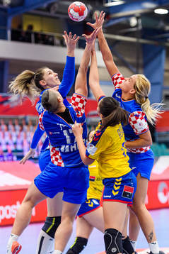 Players of Croatia and of Romania reach for the ball