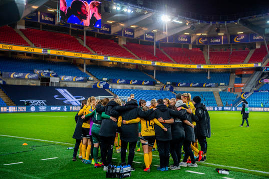 Players and staff of LSK Kvinner gather in a circle