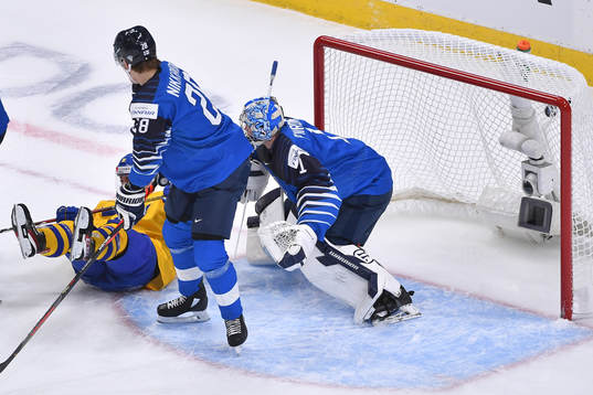Alexander Holtz of Sweden falls as the puck enters the net