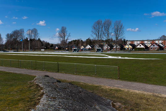 Bostadsområdet Kronogården syns bakom en gräsplan på