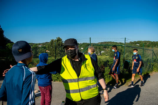 A security guard stops kids from talking to team manager