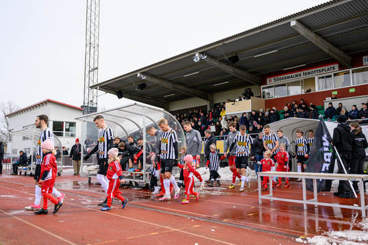 Spelarna går in på planen innan fotbollsmatchen i