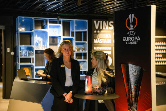 Staff greets visitors next to logos for the UEFA Europa