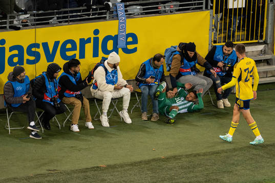 Youcef Belaili of Algeria collides with photographers