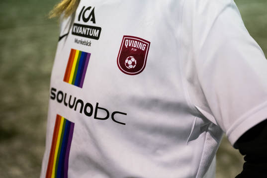 Klubbmärket på bortastället med regnbågsfärger