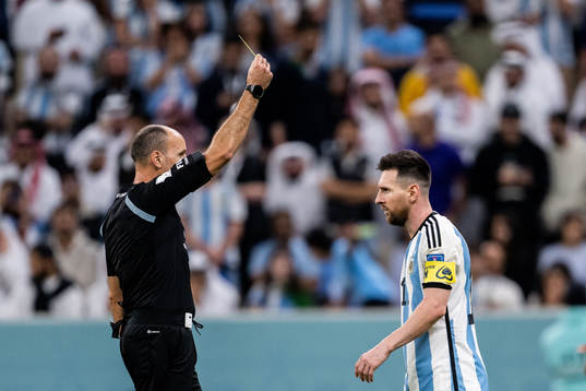 Lionel Messi of Argentina is shown a yellow card by referee