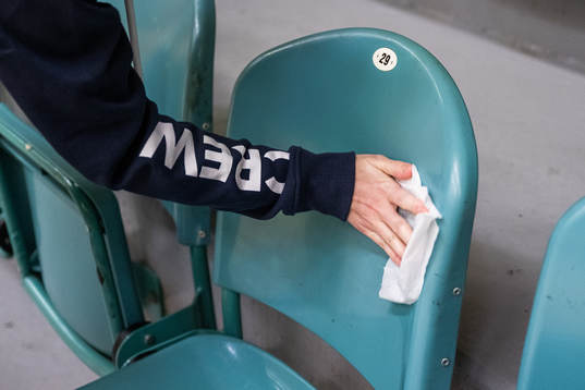 Crew disinfect chairs in the training hall