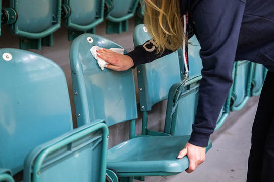 Crew disinfect chairs in the training hall