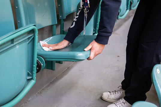Crew disinfect chairs in the training hall