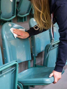 Crew disinfect chairs in the training hall