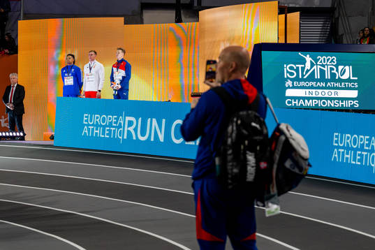 Atle Guttormsen watches the medal ceremony with Emmanouil
