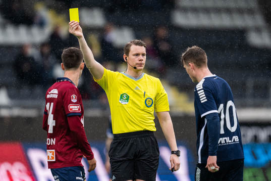 Domare Oscar Johnson visar det gula kortet