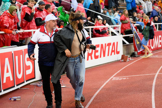 A protestor is escorted off the track