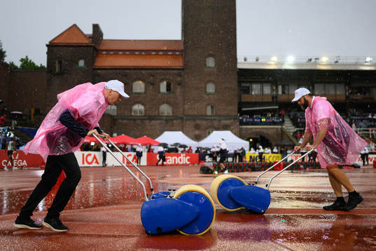 A volunteer collects rain water from the ground