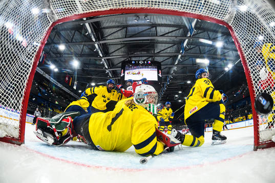Goaltender Maja Helge and Emma Rehn of Sweden watch the puck