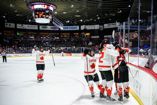 Marie-Philip Poulin of Canada celebrates with teammates