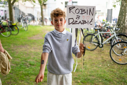 En ung kille med skyllt och tatuering på handen