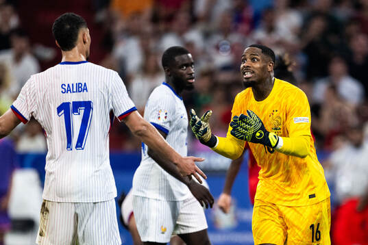 Goalkeeper Mike Maignan of France reacts towards William