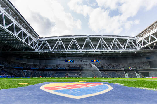 En matta med Djurgårdens klubbmärke på kostgräset på
