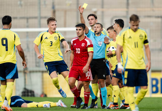 Dylan Borge of Gibraltar receives a yellow card