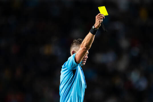 Referee Allard Lindhout shows a yellow card