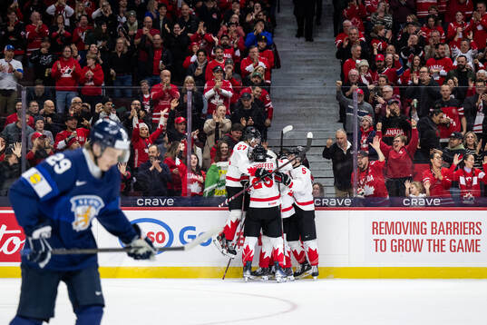 Gavin McKenna of Canada celebrates with team mates