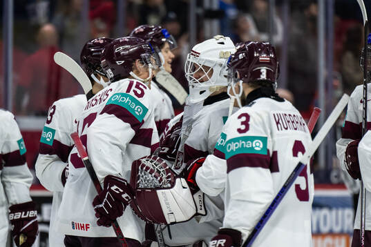 Darels Uljanskis and goaltender Linards Feldbergs of Latvia