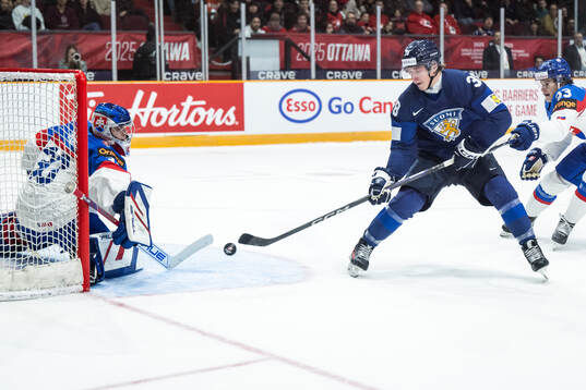 Goaltender Samuel Urban of Slovakia and Jesse Kiiskinen of