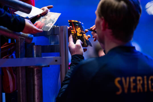 Jonathan Carlsbogård of Sweden signs a photo of him and a