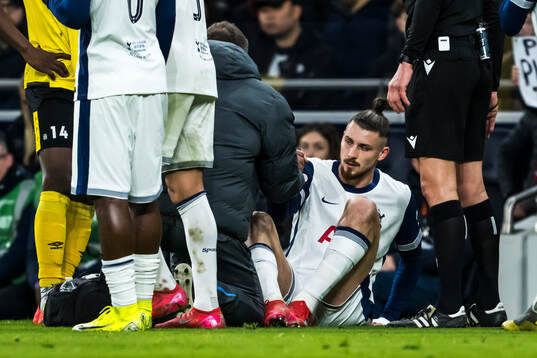 Radu Dragusin of Tottenham Hotspur in pain