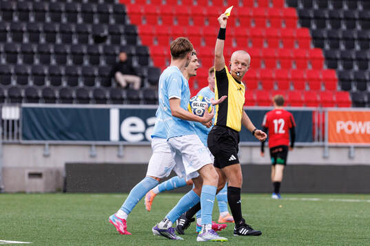 Malmö FFs Elliot Uddenäs får ett gult kort av domare