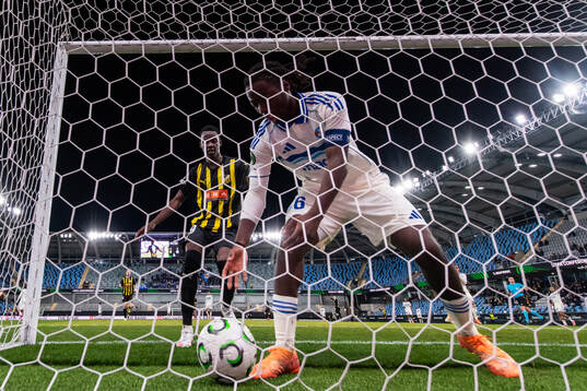 John Paul Dembe goes for the ball held by Ismael Doukoure