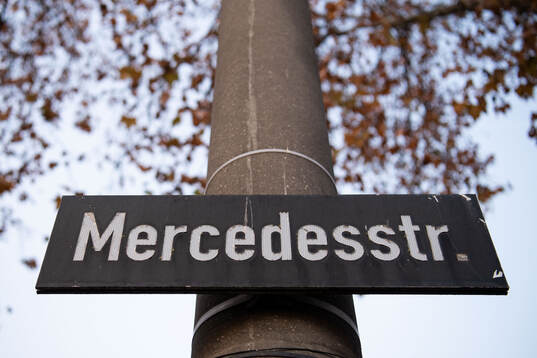 A street sign showing the name Mercedesstrasse outside
