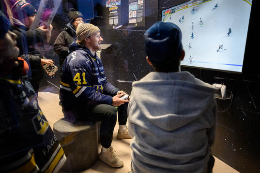 HV71s Riley Woods spelar tv-spel med besökare