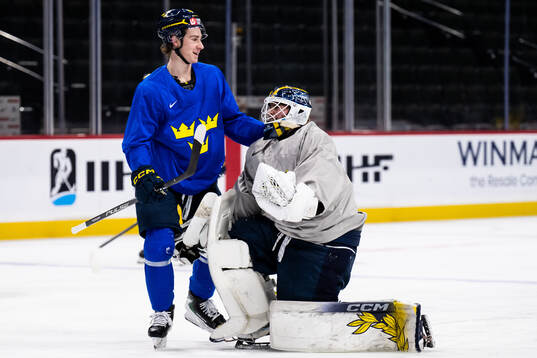 Eric Nilson and goaltender Love Härenstam of Sweden at a