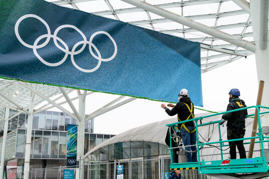 Workers are seen putting up branding at Fiera Milano