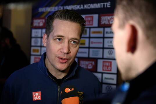 Head coach Sam Hallam is interviewed at a press conference