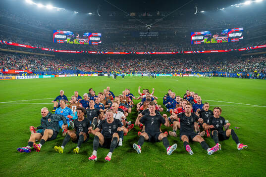 Players and staff of Norway celebrate with a viking row