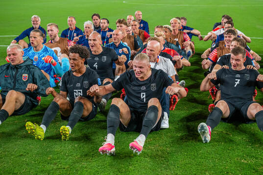 Players and staff of Norway celebrate with a viking row
