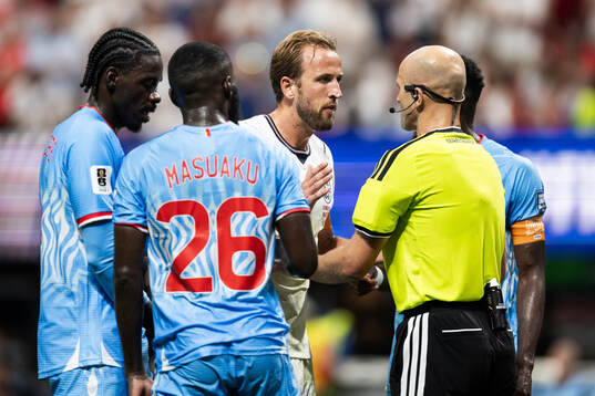 Harry Kane of England in a discussion with the referee